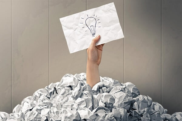 Hand holding drawing of a lightbulb under pile of crumpled paper_Image used under licence from Shutterstock Hand holding drawing of a lightbulb under pile of crumpled paper_Image used under licence from Shutterstock