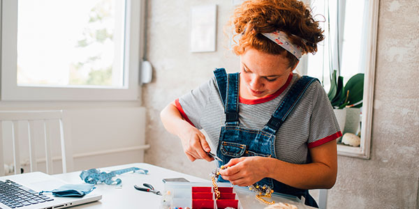 A woman making products, thinking about insurance for Etsy sellers