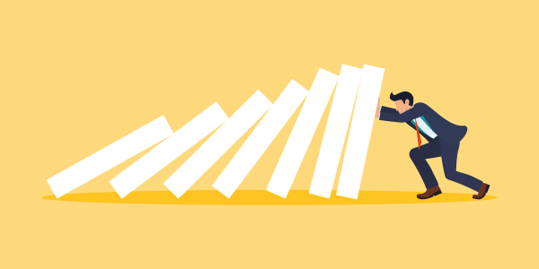A cartoon illustration of a row of blocks falling into each other. And a man trying to keep them upright representing how business interruption insurance can help your business. 